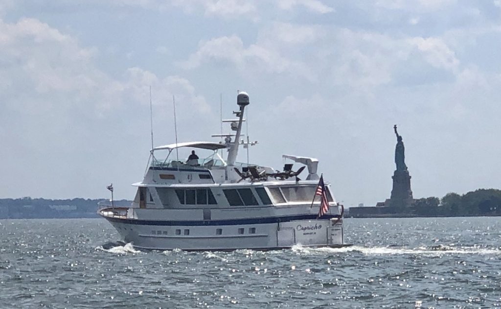 yacht sailing by statue of liberty