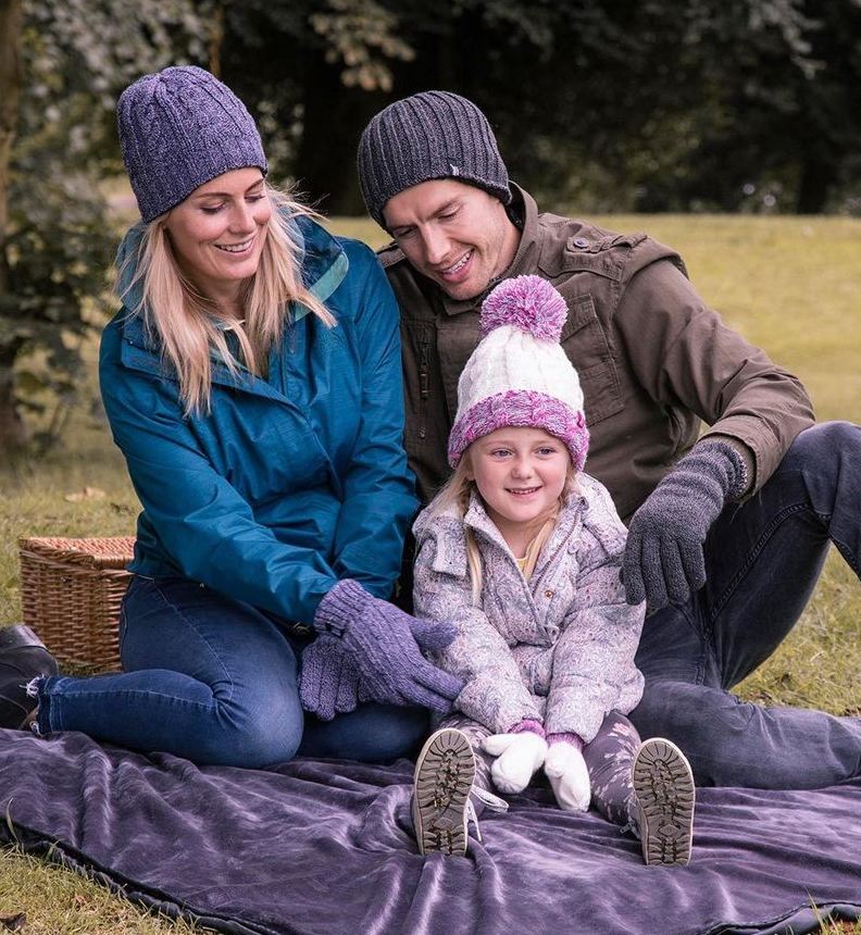 man, woman and child on picnic blanket