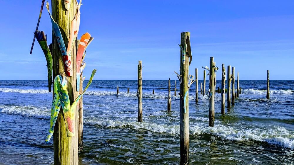 dock pilings decorated with palm fronds