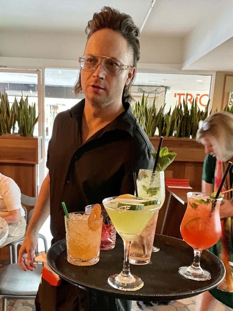 server Dominic Peterson at Trio in Palm Springs with a tray of drinks